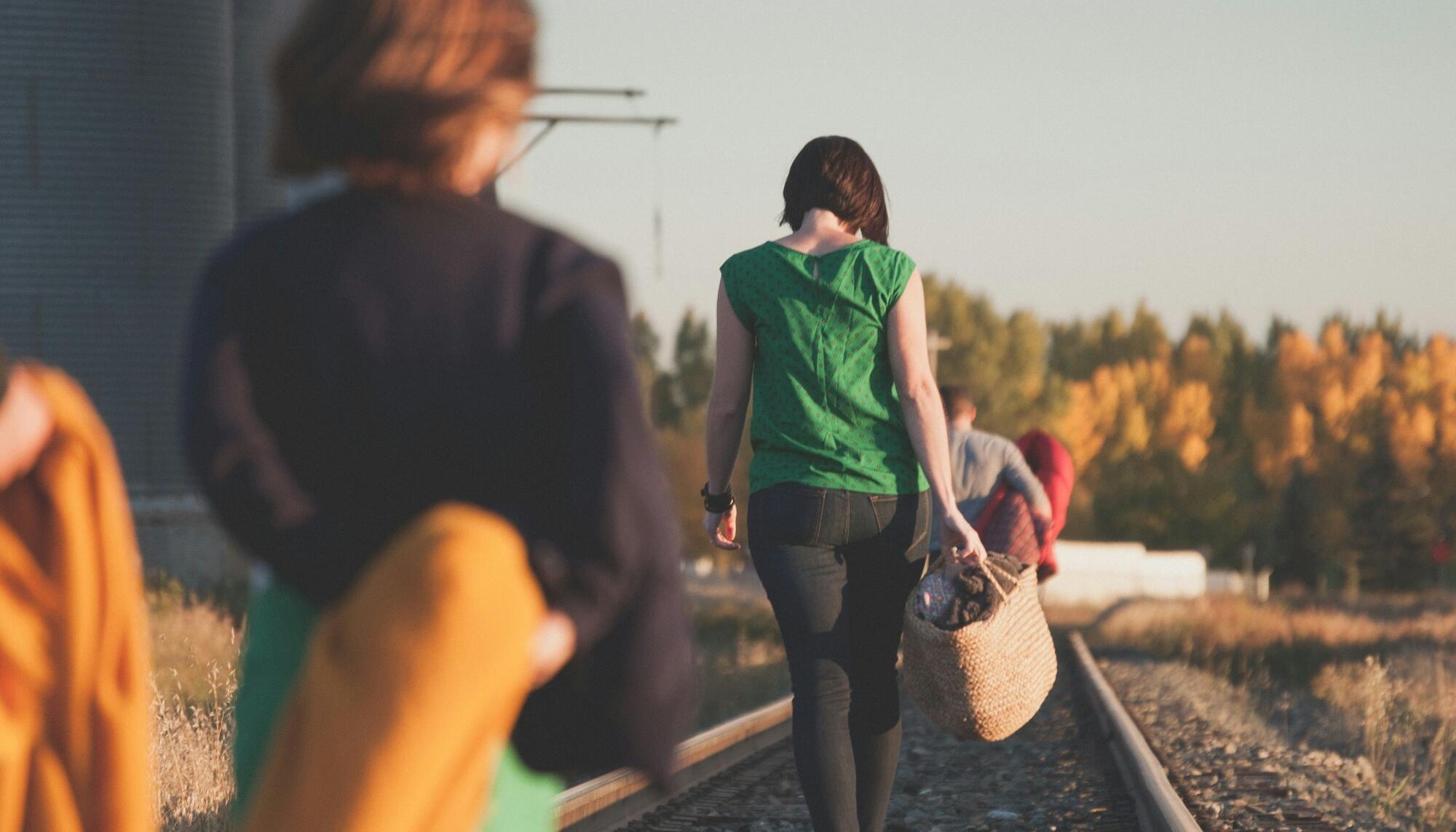 grupo de personas que caminan sobre la vía del tren